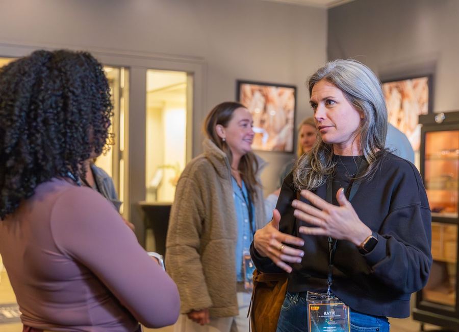 Attendees in conversation at a previous Optimizers community event