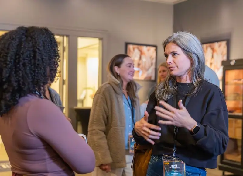 Attendees in conversation at a previous Optimizers community event